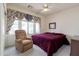 Cozy bedroom with a comfortable chair, large window and a ceiling fan at 345 S Buena Vista Ave, Gilbert, AZ 85296