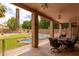 Relaxing covered patio with ceiling fans, overlooking a backyard oasis with a pool and waterfall feature at 345 S Buena Vista Ave, Gilbert, AZ 85296
