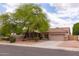 Single-story home with a beige exterior, tile roof, desert landscaping, and mature shade tree in front yard at 345 S Buena Vista Ave, Gilbert, AZ 85296