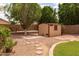 Well-maintained storage shed in a landscaped backyard with stepping stones and mature trees at 345 S Buena Vista Ave, Gilbert, AZ 85296