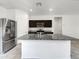 Modern kitchen features a granite island, stainless steel appliances, and dark wood cabinets at 35337 W San Alvarez Ave, Maricopa, AZ 85138