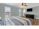 Well-lit bedroom with hardwood floors, windows, and a mounted television at 3709 W Grovers Ave, Glendale, AZ 85308