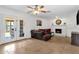 Cozy living room featuring a brick fireplace, comfortable seating, and seamless access to the backyard at 3709 W Grovers Ave, Glendale, AZ 85308