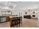 Open-concept living area with a kitchen island, connecting to a cozy living room with a brick fireplace at 3709 W Grovers Ave, Glendale, AZ 85308