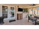 Covered patio space with tiled floor, ceiling fan, TV, and comfortable outdoor seating at 3709 W Grovers Ave, Glendale, AZ 85308