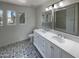 Elegant bathroom with double sinks, modern lighting, and patterned tile flooring at 4005 W Carter Rd, Phoenix, AZ 85041