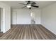 Bright bedroom with wood-look floors, ceiling fan, closet space and ensuite bathroom at 4005 W Carter Rd, Phoenix, AZ 85041