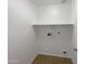 Functional laundry room featuring essential hookups and shelving for organized convenience at 4005 W Carter Rd, Phoenix, AZ 85041