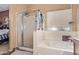 Bright bathroom featuring a glass-enclosed shower and a deep soaking tub at 44810 W Horse Mesa Rd, Maricopa, AZ 85139