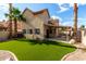 Beautiful backyard with lush artificial turf, desert landscaping, and a covered patio at 4653 W Dublin St, Chandler, AZ 85226