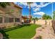 A vibrant backyard boasts lush artificial turf, a covered patio, and a mix of desert landscaping at 4653 W Dublin St, Chandler, AZ 85226