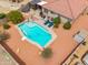 Aerial view of a backyard pool with lounge chairs and a hot tub under a covered patio at 4728 N 92Nd Ave, Phoenix, AZ 85037
