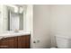 Cozy bathroom with a wood vanity, white countertop, and stylish modern lighting fixtures at 4743 N 26Th Ln, Phoenix, AZ 85017