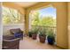 Balcony with wicker chairs, potted plants, and a view of lush green trees at 4836 S Covalent Ln, Mesa, AZ 85212