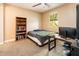 Bedroom with neutral walls, carpet, ceiling fan, and window overlooking lush trees at 4836 S Covalent Ln, Mesa, AZ 85212