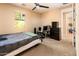 Bedroom with neutral walls, carpet, ceiling fan, and window overlooking lush trees at 4836 S Covalent Ln, Mesa, AZ 85212