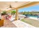 Covered patio with ceiling fans, outdoor dining area, and a view of the refreshing backyard pool at 4836 S Covalent Ln, Mesa, AZ 85212