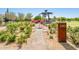 Community garden with flowers, trees, a metal gazebo, a table, and a sign at 4836 S Covalent Ln, Mesa, AZ 85212
