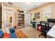 Comfortable home office with desk space, shelves, a blue couch, and bright natural light at 4836 S Covalent Ln, Mesa, AZ 85212