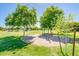 Community playground area with trees, green grass, and a swing set at 4836 S Covalent Ln, Mesa, AZ 85212