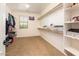 Spacious walk-in closet with ample shelving, hanging rods, and natural light from the window at 4836 S Covalent Ln, Mesa, AZ 85212