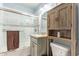 Cozy bathroom featuring a shower-tub combo with glass doors, gray vanity, and rustic wooden storage cabinet at 5025 N 20Th Ave, Phoenix, AZ 85015