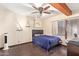 Bedroom with dark wood floors, ceiling fan, wooden beams, and a black headboard bed with blue bedding at 5025 N 20Th Ave, Phoenix, AZ 85015