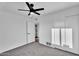 This bedroom features neutral carpeting, white walls and trim, a ceiling fan, and direct access to a closet at 607 E Holmes Ave, Mesa, AZ 85204