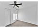This bedroom features neutral carpeting, white walls and trim, a ceiling fan, and direct access to a closet at 607 E Holmes Ave, Mesa, AZ 85204