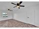 Bright bedroom featuring dual ceiling fans, a window with natural light, and a white door at 607 E Holmes Ave, Mesa, AZ 85204