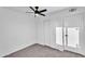 This bedroom features neutral carpeting, white walls and trim, a ceiling fan, and direct access to a closet at 607 E Holmes Ave, Mesa, AZ 85204