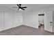 This bedroom features neutral carpeting, white walls and trim, a ceiling fan, and an ensuite bathroom at 607 E Holmes Ave, Mesa, AZ 85204