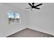 This bedroom features neutral carpeting, white walls and trim, a ceiling fan, and neighborhood views at 607 E Holmes Ave, Mesa, AZ 85204