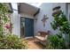 Inviting front entry featuring a dark blue door, bench seating, and mature greenery at 6206 E Avalon Dr, Scottsdale, AZ 85251