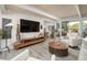 Bright and airy living room with wood-look floors, white leather furniture, and sliding glass doors at 6206 E Avalon Dr, Scottsdale, AZ 85251