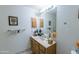Traditional bathroom features a single sink vanity with a large mirror and cabinet storage at 6445 W Windsor Blvd, Glendale, AZ 85301