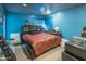 Bedroom in blue with a bed, books, white chair, and guitar case at 6445 W Windsor Blvd, Glendale, AZ 85301