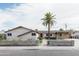 Charming single-story home with a palm tree, block fence, and covered parking at 6445 W Windsor Blvd, Glendale, AZ 85301