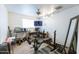 Home gym boasts a weight bench, desk, television, and ceiling fan, perfect for workouts at 6445 W Windsor Blvd, Glendale, AZ 85301