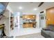Open-concept kitchen with stools, a bar, white appliances, and tile flooring at 6445 W Windsor Blvd, Glendale, AZ 85301