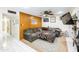 Cozy living room features wood paneling, fan, gray sectional couch, and Saints blanket at 6445 W Windsor Blvd, Glendale, AZ 85301