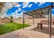 Lush backyard featuring an artificial grass lawn, shed, covered patio, and brick pavers at 6908 W Sunnyside Dr, Peoria, AZ 85345