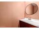 Bathroom with a round mirror and a vanity, offering a functional and private space at 6908 W Sunnyside Dr, Peoria, AZ 85345