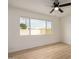 Bright bedroom with a ceiling fan, a large window, and wood-look flooring at 7125 N 23Rd Ave, Phoenix, AZ 85021