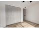 Spacious bedroom with wood-look floors and closet with gray folding doors at 7125 N 23Rd Ave, Phoenix, AZ 85021