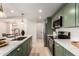 Stylish kitchen with quartz countertops, stainless steel appliances, and green cabinetry at 7125 N 23Rd Ave, Phoenix, AZ 85021