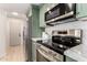 Updated kitchen with stainless steel appliances, green cabinetry, and marble countertops at 7125 N 23Rd Ave, Phoenix, AZ 85021