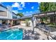 Backyard with in-ground pool, mature trees, and an outdoor kitchen area under a pergola at 7949 W Pershing Ave, Peoria, AZ 85381