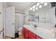 Bathroom with a decorative shower curtain, a red vanity and modern lighting at 7949 W Pershing Ave, Peoria, AZ 85381