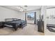 Comfortable bedroom featuring carpeted flooring, ceiling fan, a view to the backyard, and stylish furnishings at 7949 W Pershing Ave, Peoria, AZ 85381